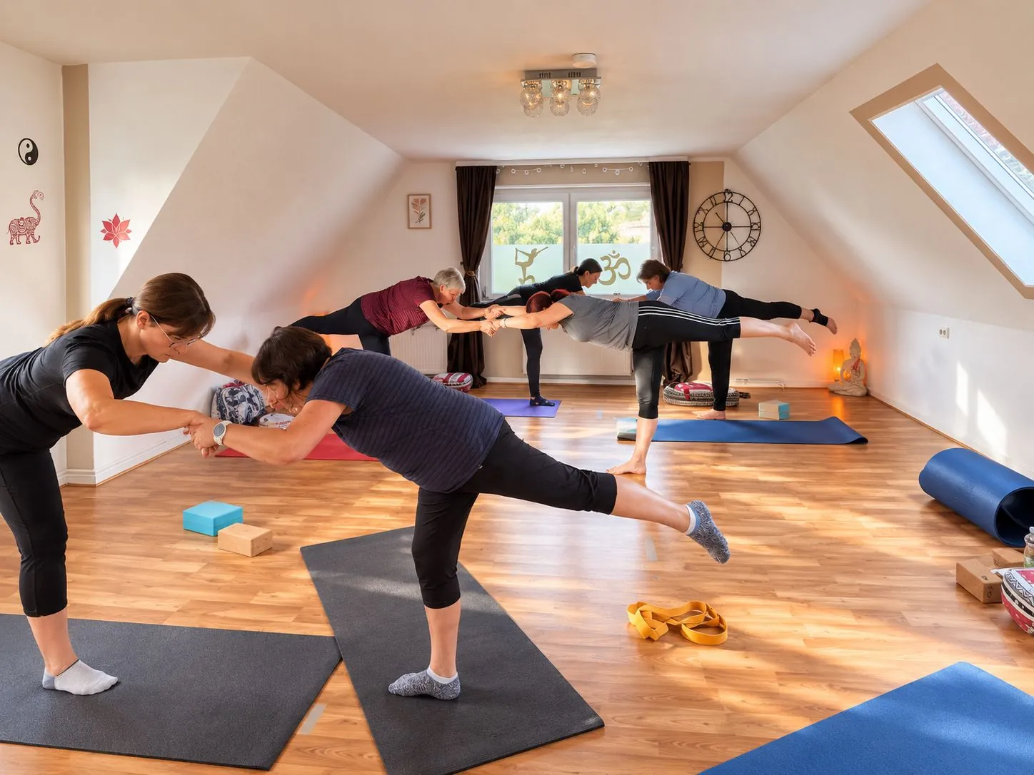 Yogagruppe bei einer gemeinsamen Balanceübung im Studio