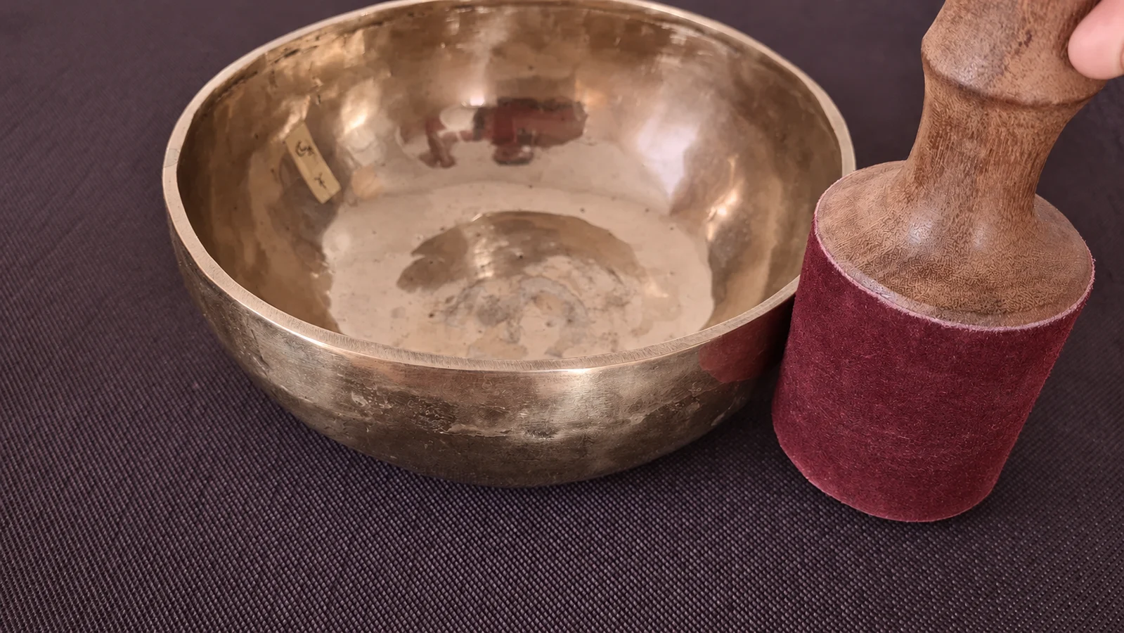 Klangschale aus Bronze mit Schlägel auf einer Yogamatte