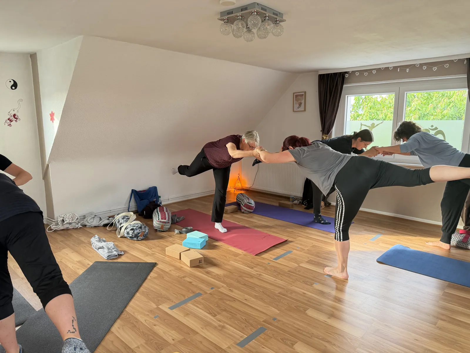 Teilnehmende unterstützen sich bei einer gemeinsamen Balanceübung